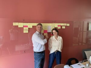 deux personnes devant un tableau de post it lors d'une workshop agile